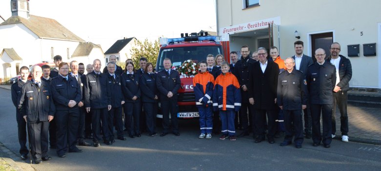 Die Aktiven der Freiwillige Feuerwehr und die Offiziellen stehen vor dem neuen Fahrzeug.