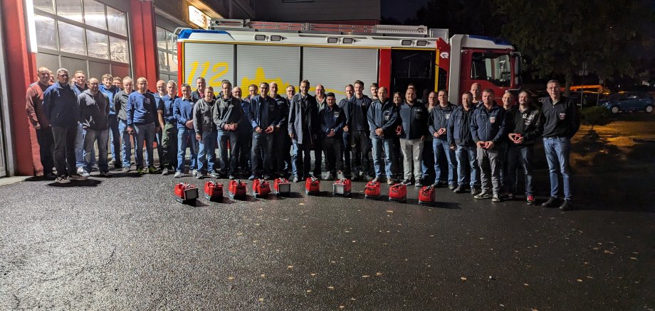 Außenaufnahme der Feuerwehrmitglieder vor dem Feuerwehrhaus